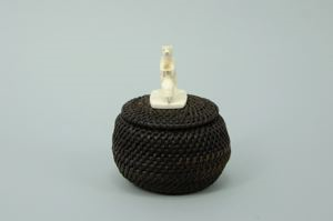 Image: round baleen basket with standing bear and seal on finial